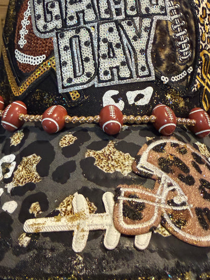 Blu Coconut black, gold and silver Game Day leopard print football trucker hat.